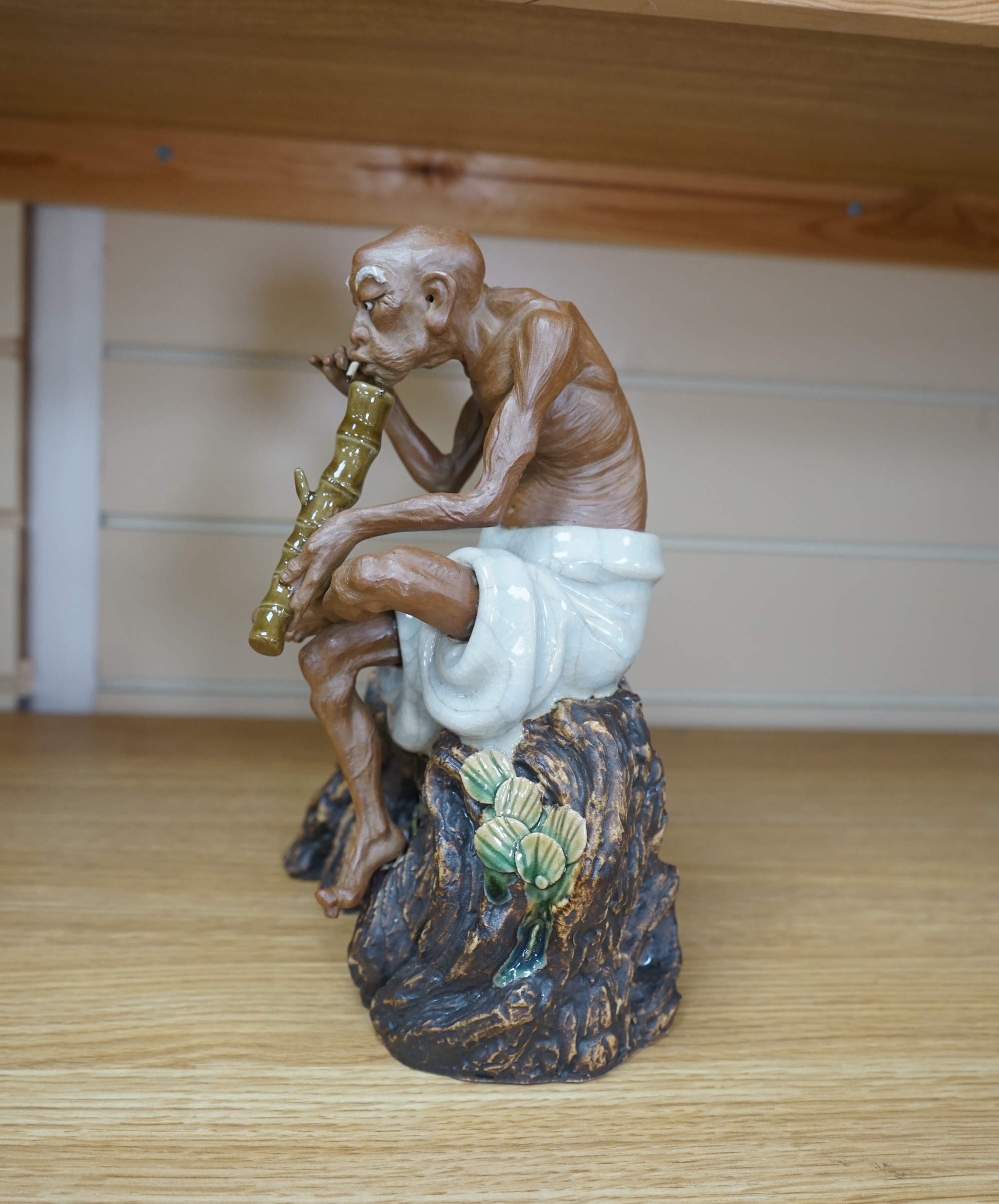 A 20th century Chinese figure of an opium smoker, maker’s seal to reverse and inscribed to interior base, 25cm. Condition - good